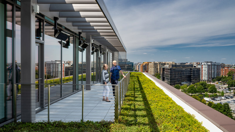 Two people on the green rooftop of 20 Mass Ave overlooking the Washington, D.C. skyline.