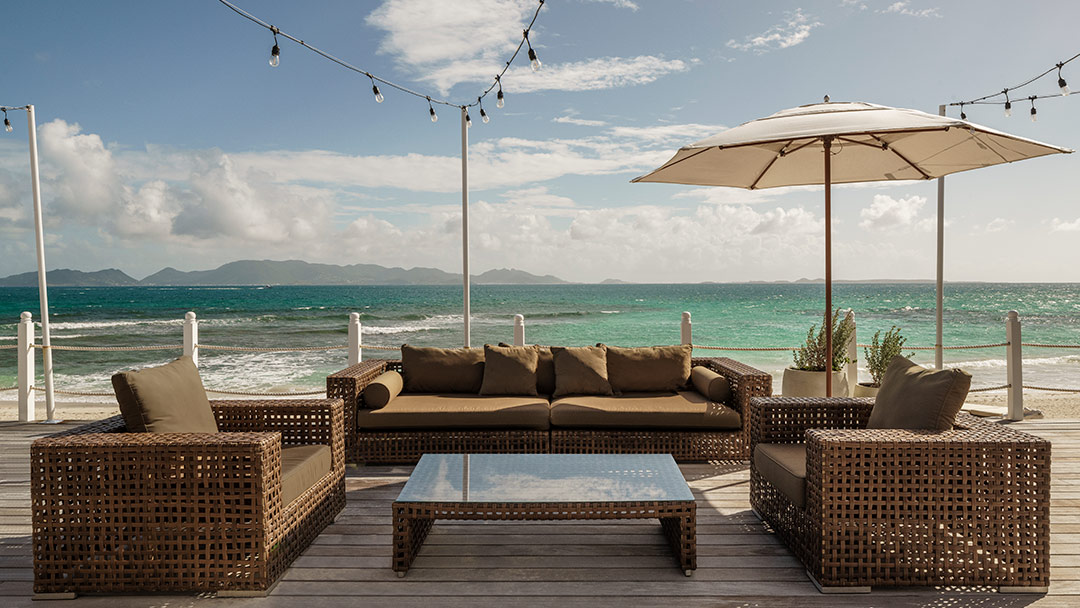 casual couch and lounge seating with umbrella overlooking ocean